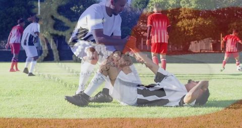 Soccer team supporting injured player during outdoor practice