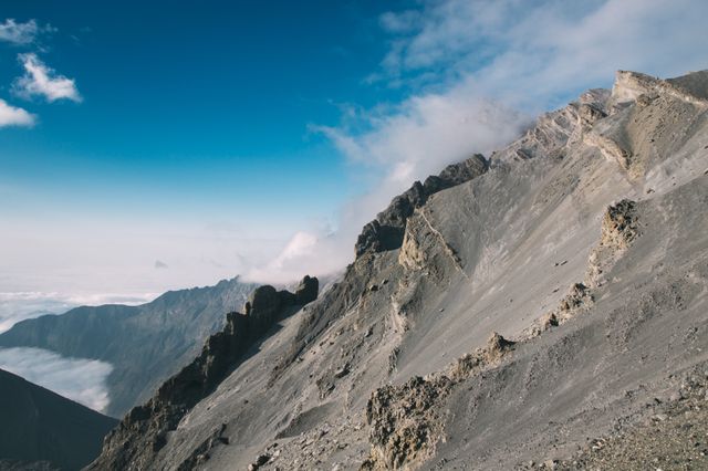 Dramatic Volcanic Mountain Ridge Under Blue Sky - Download Free Stock Photos Pikwizard.com