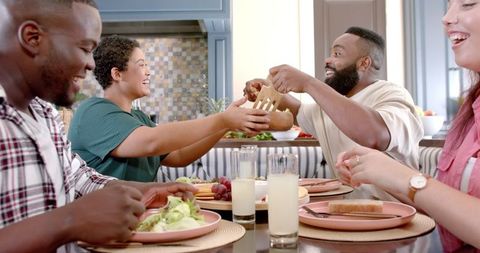 Friends Enjoying Meal Together at Home Dining Table