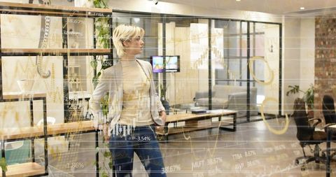 Woman standing and gazing in open-plan office with financial charts overlay