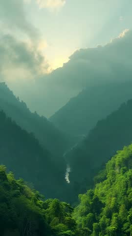Vertical Video Sun Breaking Through Clouds Over Misty Mountain Valley With Winding River