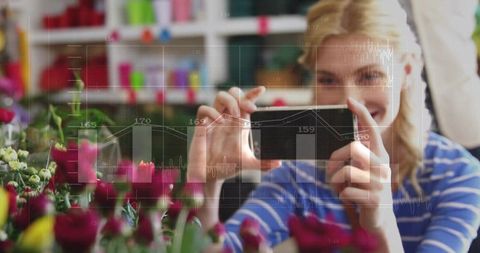 Woman capturing roses with smartphone in florist shop with analytics hud overlay