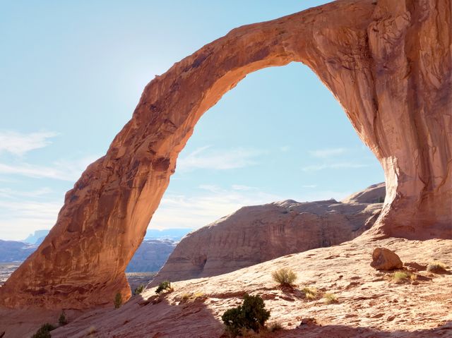 This natural stone arch in a desert landscape can be used for travel brochures, geology educational materials, and nature-themed designs. It showcases the beauty of natural rock formations and can inspire outdoor adventure and exploration.