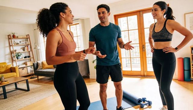 Home group fitness session with energetic trio leading workout in bright living room