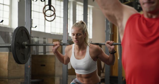 Focused woman lifting barbell during workout at gym - Download Free Stock Images Pikwizard.com