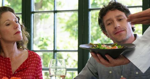 Couple Attentively Listening to Chef Presenting Dish