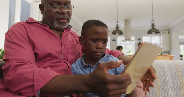 Grandfather and Grandson Using Digital Tablet in Living Room - Download Free Stock Images Pikwizard.com