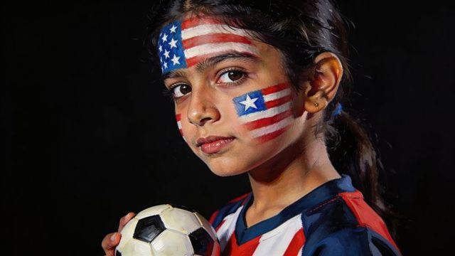Preteen soccer player wearing american flag face paint holding ball, patriotic youth portrait