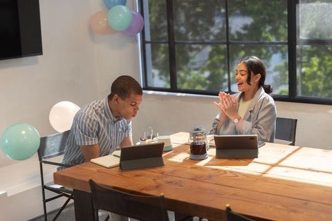 Cheerful office celebration: colleagues enjoying birthday at workspace