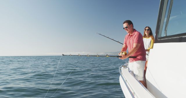 Couple smiling and fishing on a boat in the open ocean on a bright summer day. Perfect for concepts related to summer vacations, travel, outdoor activities, recreation, relaxing, and adventure sports.