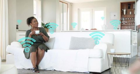 Middle-aged woman relaxing on sofa in smart home with wifi signal icons