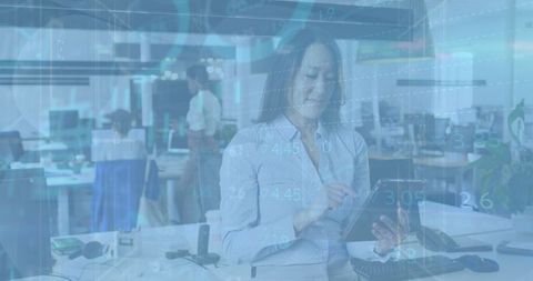 Asian Businesswoman Analyzing Financial Data on Digital Tablet in Modern Office