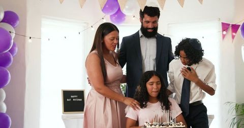 Family Celebrating Bat Mitzvah at Home with Cake and Decorations