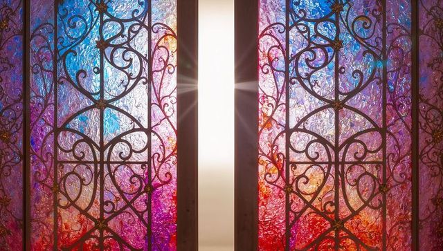 Ornate Wrought Iron Scrollwork Behind Colorful Stained Glass