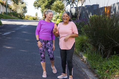 Smiling Mature Women Enjoying Walk on Suburban Street