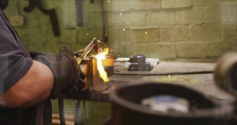Gloved welder cutting thick metal with cutting torch producing bright sparks in workshop