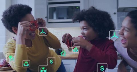 Family trio playing with red toy rings in home kitchen, laughing and bonding during playful cooking