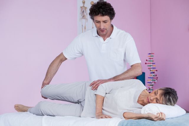 Physiotherapist treating senior woman in clinic, focusing on leg massage. Ideal for illustrating healthcare, rehabilitation, elderly care, and physical therapy services. Useful for medical websites, brochures, and articles on senior wellness and recovery.