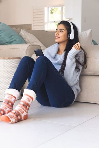 Relaxed Young Woman Listening to Music on Headphones at Home