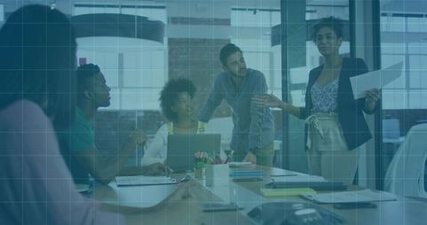 Leading presenter guiding team through strategic brainstorming in glass conference room