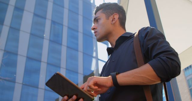 Focused Young Professional Using Tablet Outdoors near Modern Office Building - Download Free Stock Images Pikwizard.com