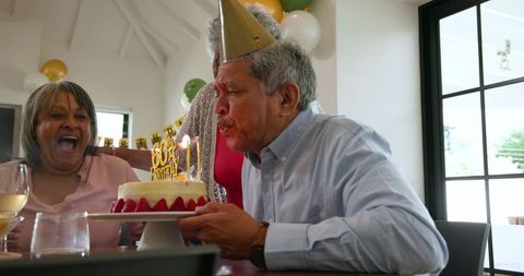Cheerful seniors celebrating birthday party with joyful laughter