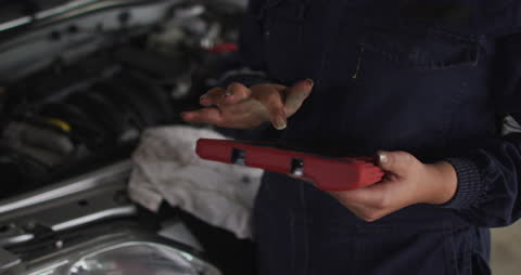 Female Mechanic Using Tablet in Service Station for Automotive Diagnostics