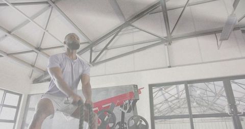 Man performing battle rope workout in industrial gym for strength and cardio
