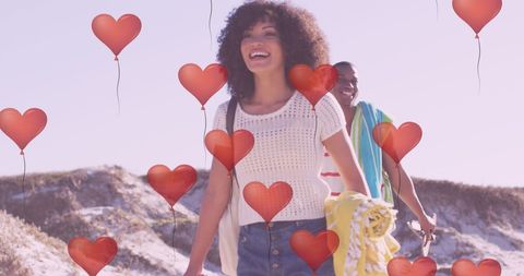 Joyful couple at beach with floating hearts