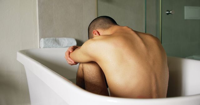 Man Sitting Inside a Bathtub Hugging Knees with Downcast Face - Download Free Stock Images Pikwizard.com
