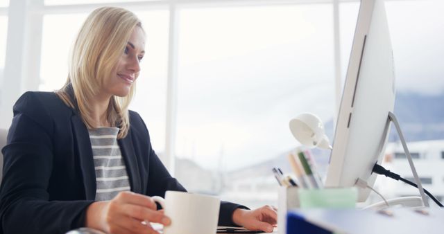 Businesswoman Working on Desktop with Coffee in Hand - Download Free Stock Images Pikwizard.com