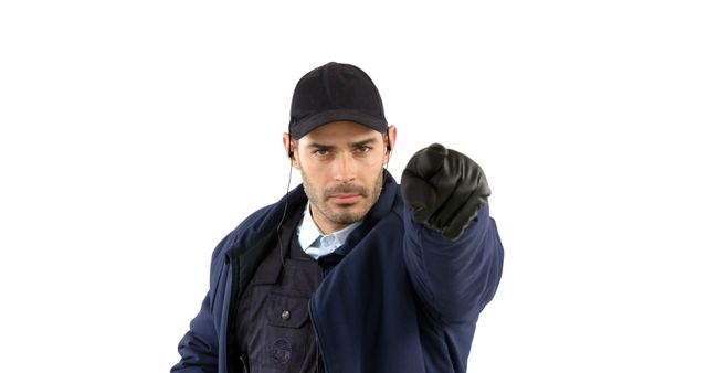 A young Caucasian man dressed as a security guard is gesturing to stop with his hand extended, with copy space. His serious expression and authoritative gesture suggest he is enforcing a rule or boundary.
