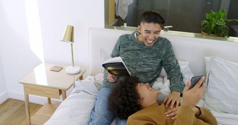 Interracial Couple Relaxing in Cozy Bedroom Setting