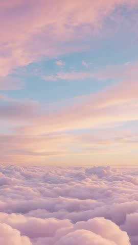 Vertical drone video gliding over pastel clouds at sunrise with shifting pink and blue sky