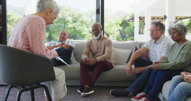 Group of seniors sitting and conversing in a bright, modern living room. Ideal for content related to senior living, retirement communities, social activities, healthy aging, or leisure time among older adults.