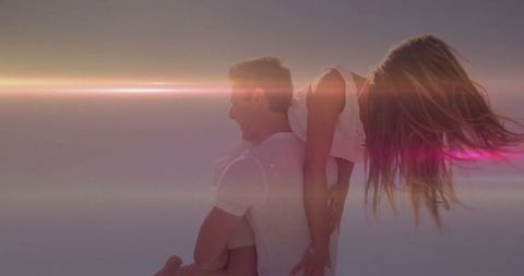 Couple Enjoying Playful Piggyback Ride at Sunset