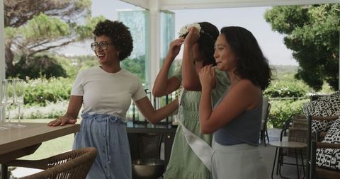 Joyful friends embracing at outdoor bridal shower with scenic backdrop
