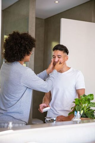 Couple enjoying skincare routine in minimalist bathroom