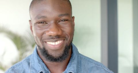 Smiling Man Wearing Denim Shirt in Modern Interior