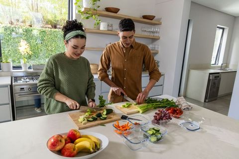 Young couple preparing healthy meal together in modern sunlit kitchen