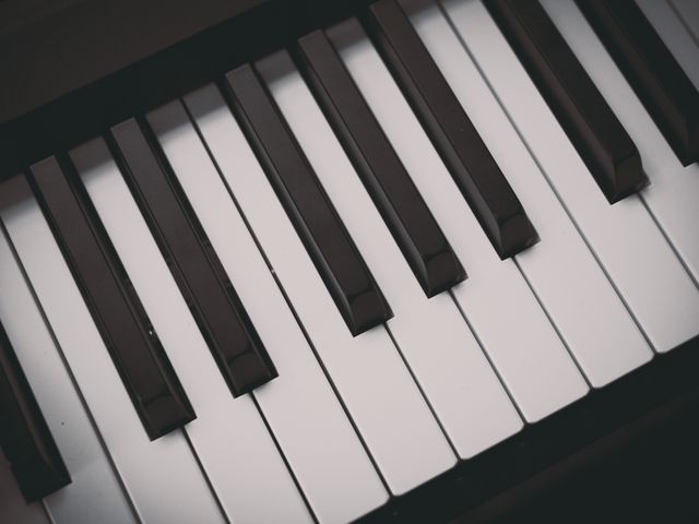 This detailed close-up captures the piano keys with rich lighting creating a contrast between the black and white keys. Perfect for use in music-related content, musician websites, instrument learning guides, or classical music concert promotions.