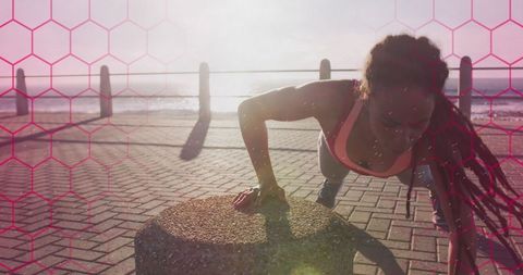 Fit African American Woman Doing Push Ups at Seafront