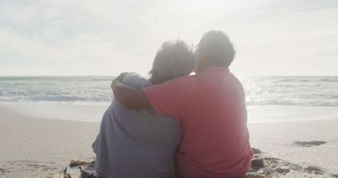 Happy Senior Couple Embracing on Tranquil Beach at Sunset