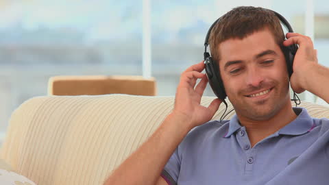 Relaxed Man Enjoying Music with Headphones on Sofa