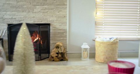 Cozy living room fireplace glowing fire with lantern, stacked firewood and woven basket