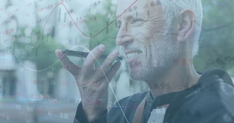 Senior Man Engaged with Smartphone Amidst Financial Charts