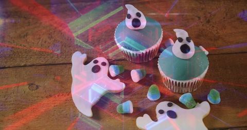 Playful halloween ghost shaped candy on wooden surface