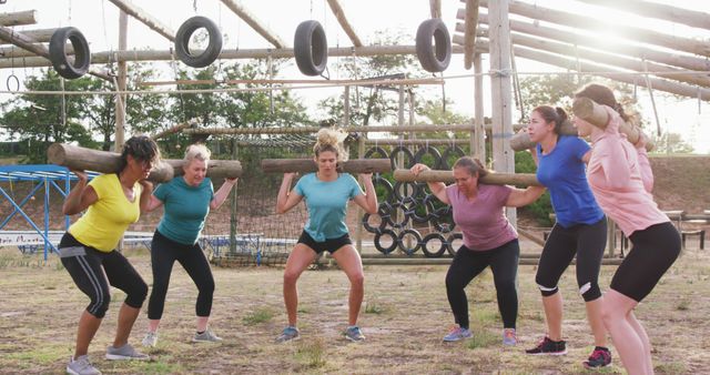 Women performing team-building exercises in outdoor obstacle course. Great for illustrating teamwork, fitness training, outdoor activities, team spirit, group bonding, and coordinated effort in exercise programs and motivational settings.
