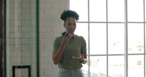 Confident Businesswoman Holding Smartphone Enthusiastically Presenting