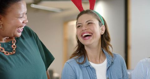 Diverse Coworkers Laughing and Sharing Joy in Casual Office Holiday Moment